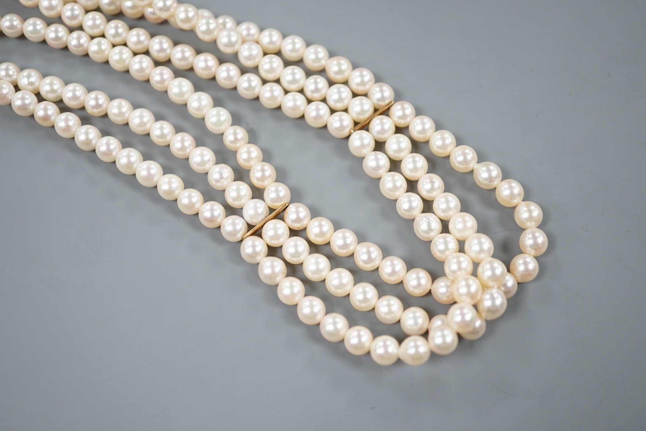 A triple strand cultured pearl necklace with 750 yellow metal clasp, 32cm.
